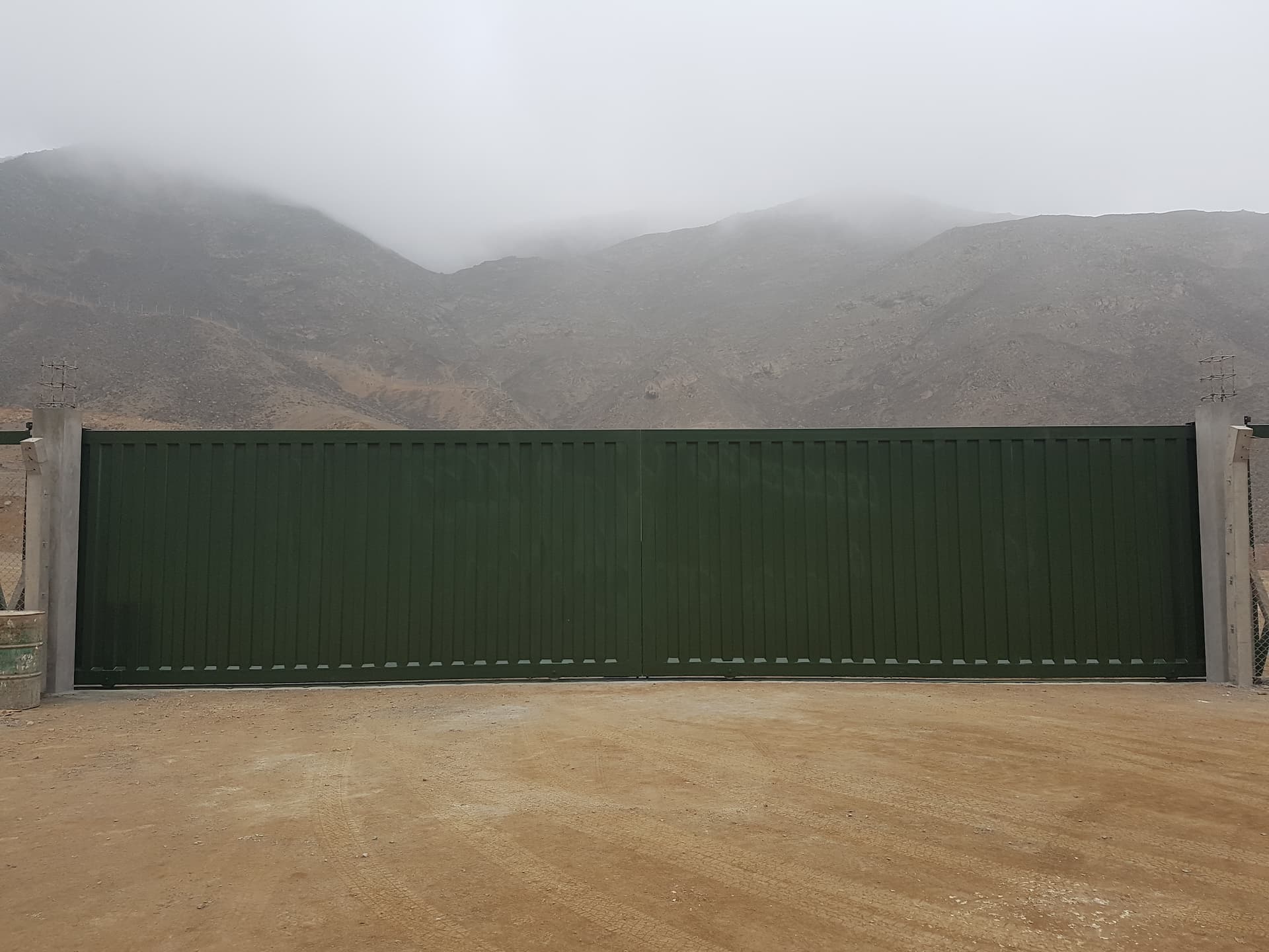 Portón corredizo industrial verde oscuro instalado de frente por Lopez Sistemas