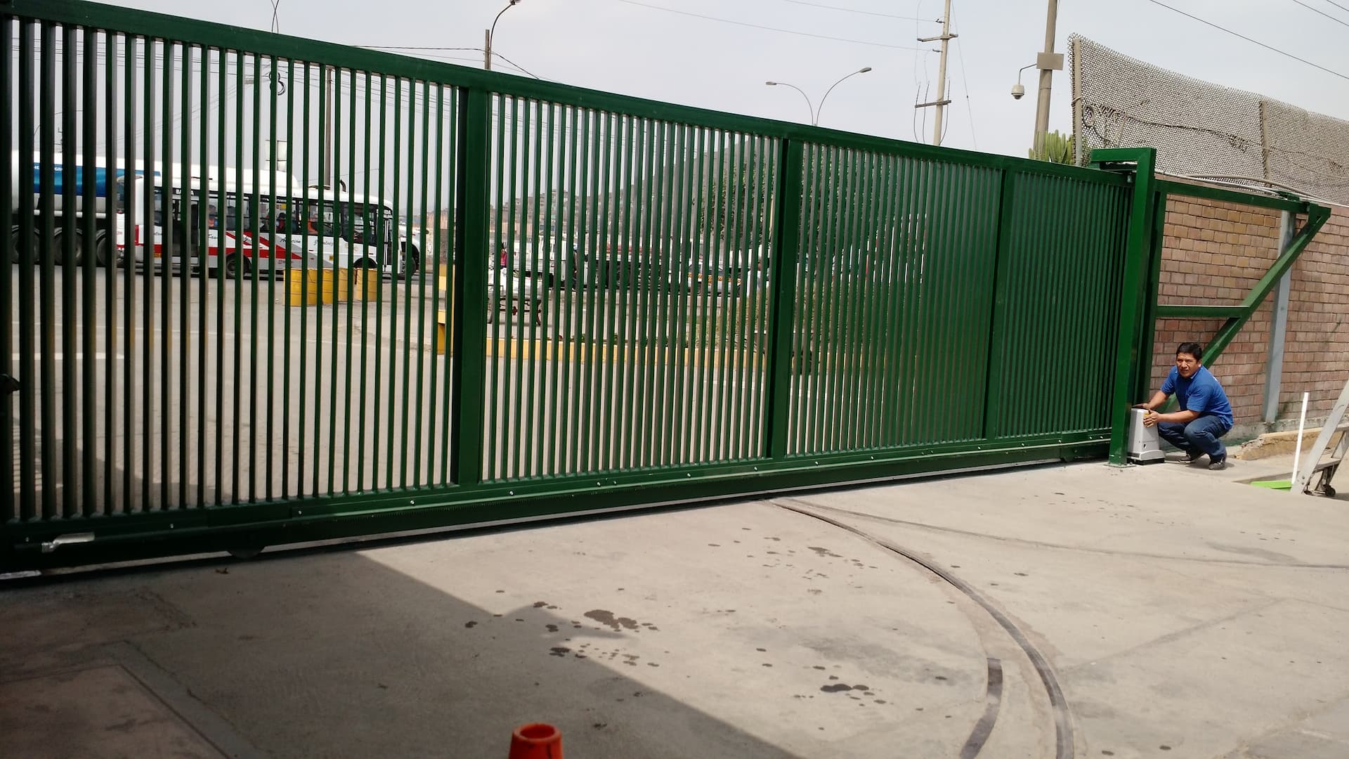 Portón corredizo industrial verde tipo reja instalado de frente por Lopez Sistemas